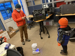 One of Cochran Hameen's students demonstrates a robot to a child