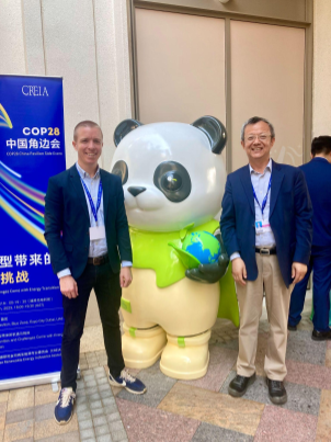 Two people stand next to a panda statue